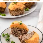 A meatloaf cupcake cut in half on a plate.