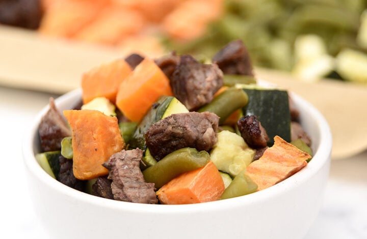 Homemade beef and veggie dog food cooked on a sheet pan in the oven.