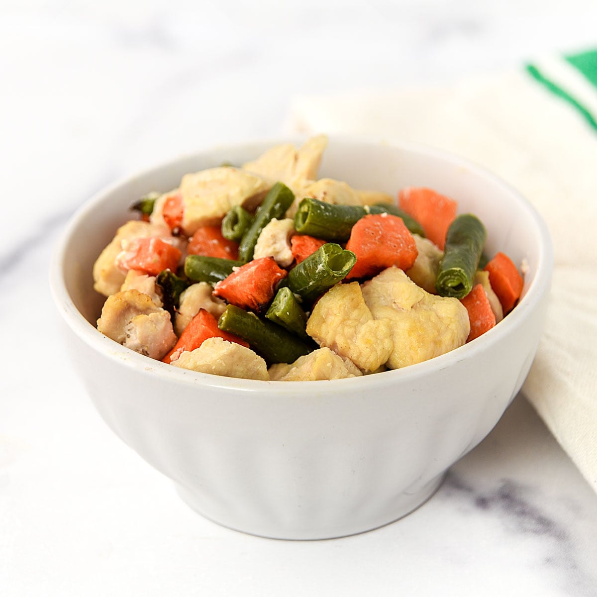 Air fryer chicken and veggie dog food in a small bowl.