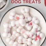 Bone-shaped frozen yogurt dog treats with fruit on a plate.