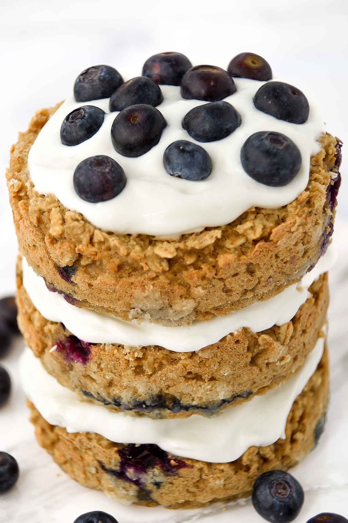 Blueberry oatmeal cake with Greek yogurt frosting topped with fresh blueberries.