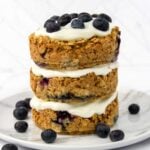 Homemade blueberry cake for dogs with yogurt frosting topped with fresh blueberries.