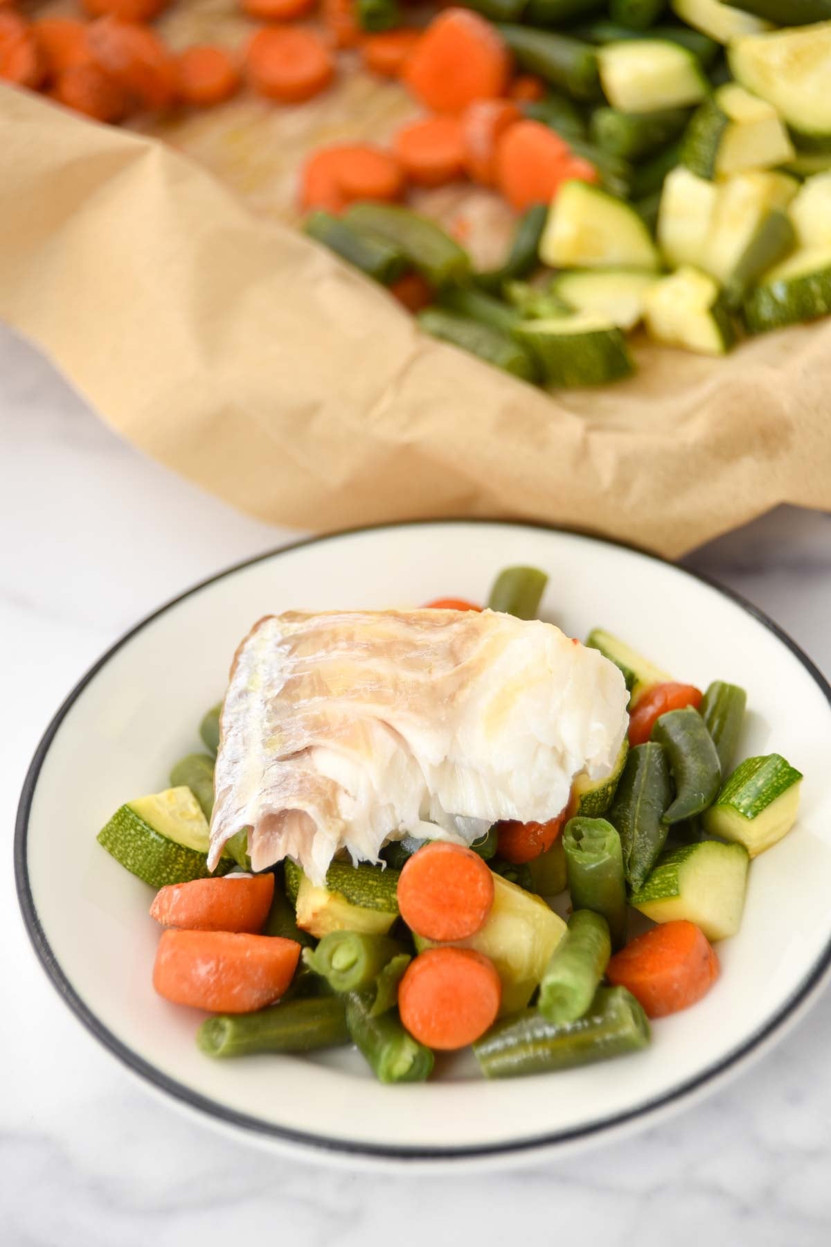 Sheet pan baked cod, carrots, green beans, and zucchini.
