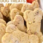 A bowl of bone-shaped homemade apple bacon dog treats.