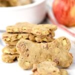 Homemade apple bacon dog treats in a stack and one in front of it.