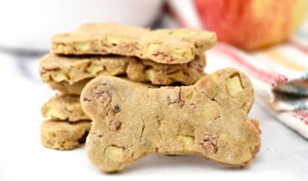 Homemade dog treats with apple and bacon on a kitchen counter.