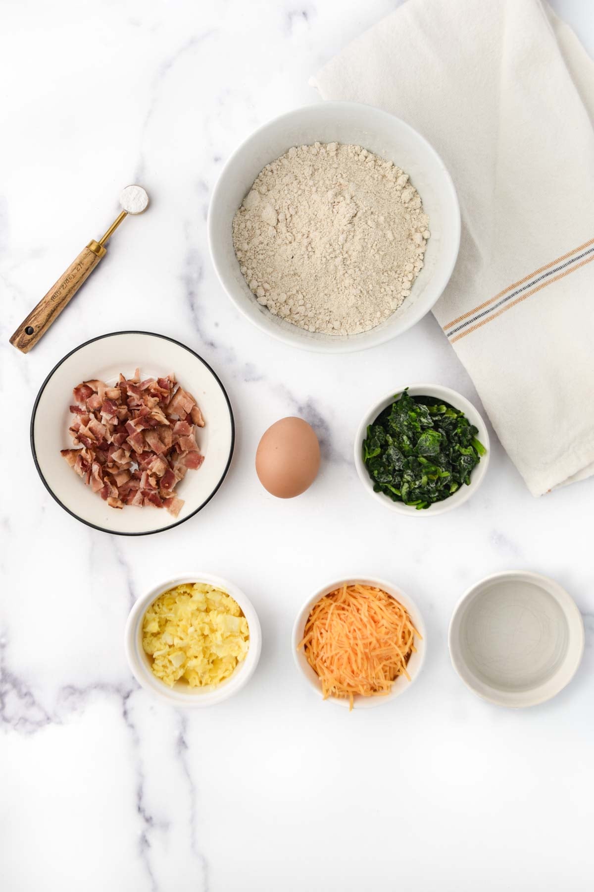 Cooked bacon, egg, shredded cheese, chopped spinach, oat flour, baking powder, and water.