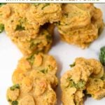 Homemade kale dog treats in a paw shape on a marble surface.