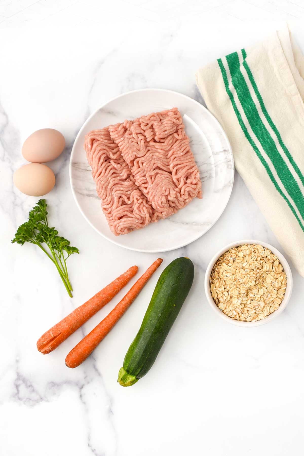 Ground chicken, carrots, zucchini, eggs, oats, and curly parsley.