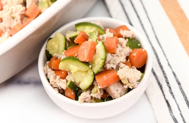 A bowl of baked ground chicken and veggies made for dogs.