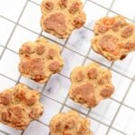 Paw-shaped homemade apple carrot dog treats on a wire rack.