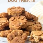 Homemade paw-shaped applesauce dog treats on and beside a plate.