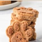 Paw-shaped homemade applesauce dog treats in a stack and one in front.