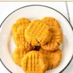 A plate of no-bake peanut butter dog treats shaped like classic peanut butter cookies.