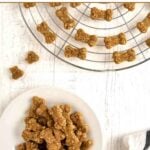 Bone-shaped homemade dog treats made without flour on a rack and a plate.