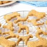 Dog and bone-shaped homemade peanut butter banana dog treats on a wire rack.