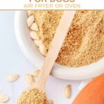 Homemade roasted and ground pumpkin seeds for dogs in a bowl and on a spoon.