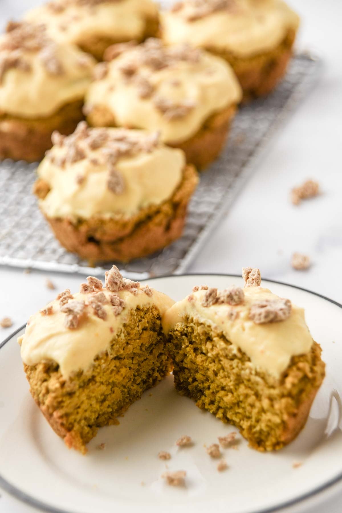 Pumpkin cupcakes with creamy yogurt frosting and crushed dog treats on top.