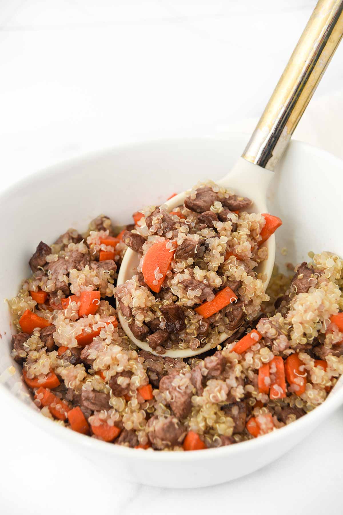 Air-fried beef and carrots mixed with quinoa in a bowl.