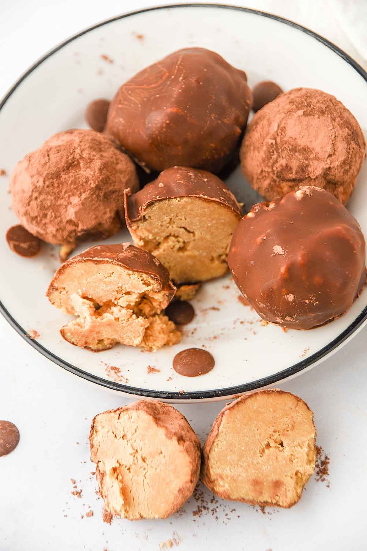 Homemade no-bake peanut butter carob truffles for dogs, carob chips, and carob powder on a plate.